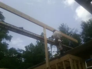 Carpenter setting a ridge beam over a new addition frame — Ice Dam Removal by Roofing Brothers in Dike