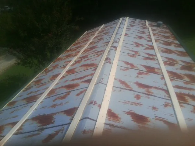 Rusted metal roof panels with new wood purlins before replacement — Storm Damage Roof Repair in Dike by Roofing Brothers